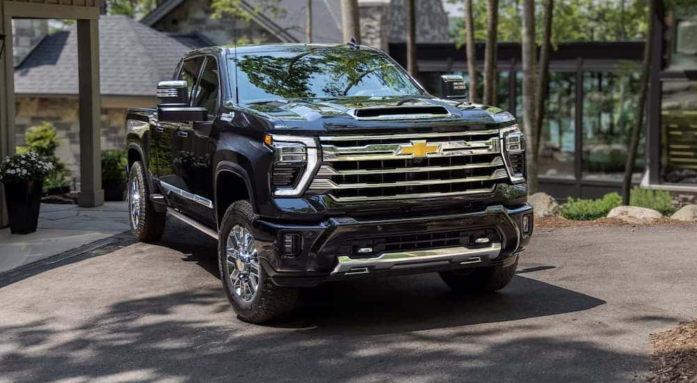 A black 2025 Chevy Silverado 2500 High Country parked in a driveway.