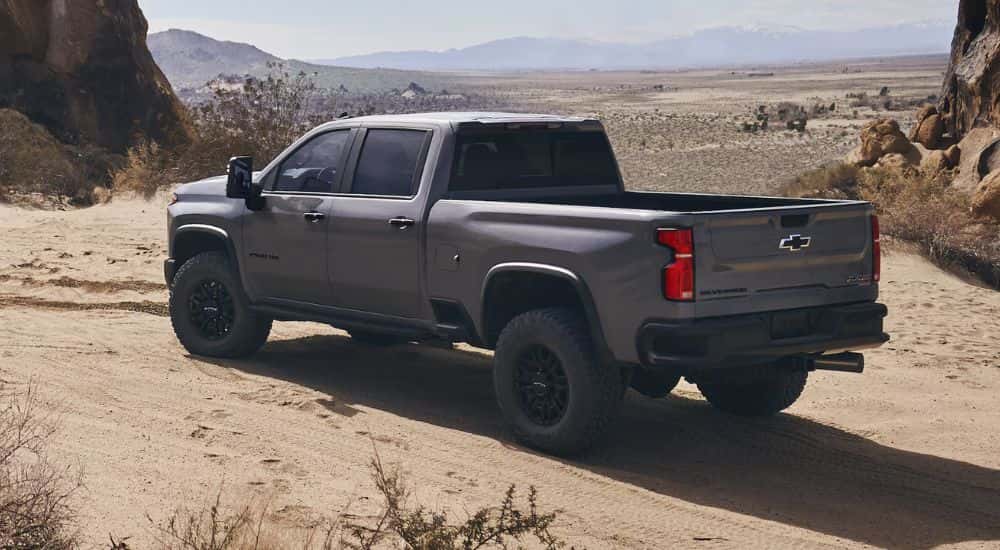 Rear view of a grey 2025 Chevy Silverado 2500 parked overlooking a desert area.