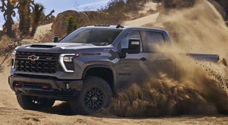 A grey 2024 Chevy Silverado 2500 HD ZR2 driving off-road through a desert.