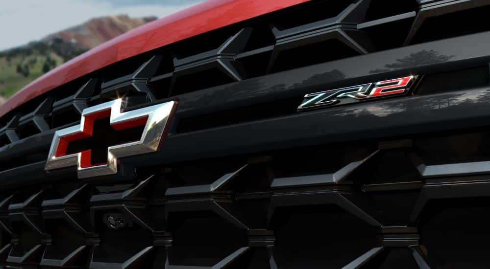 Close-up on the badge and grille of a red 2024 Chevy Silverado 2500 HD ZR2.