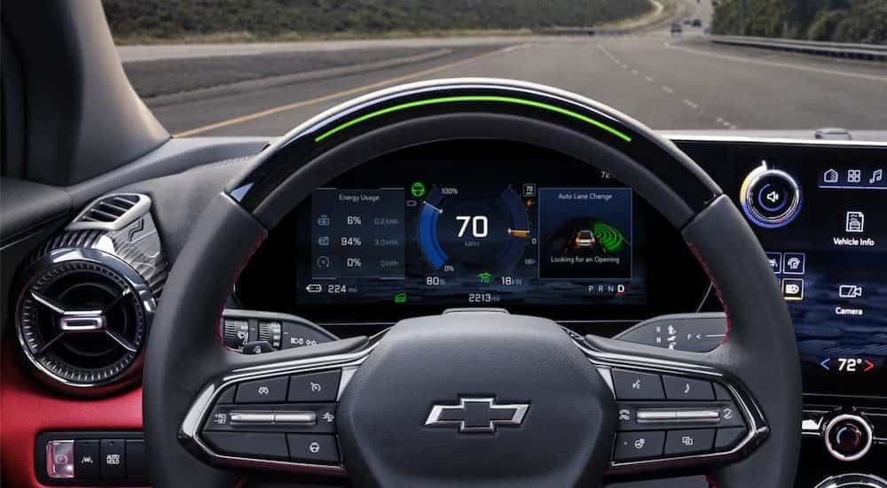 A close-up of the steering wheel and digital dash display are shown in a 2025 Chevy Blazer EV for sale.