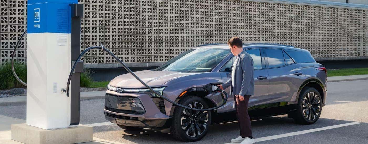 A grey 2024 Chevy Blazer EV parked by a charger.