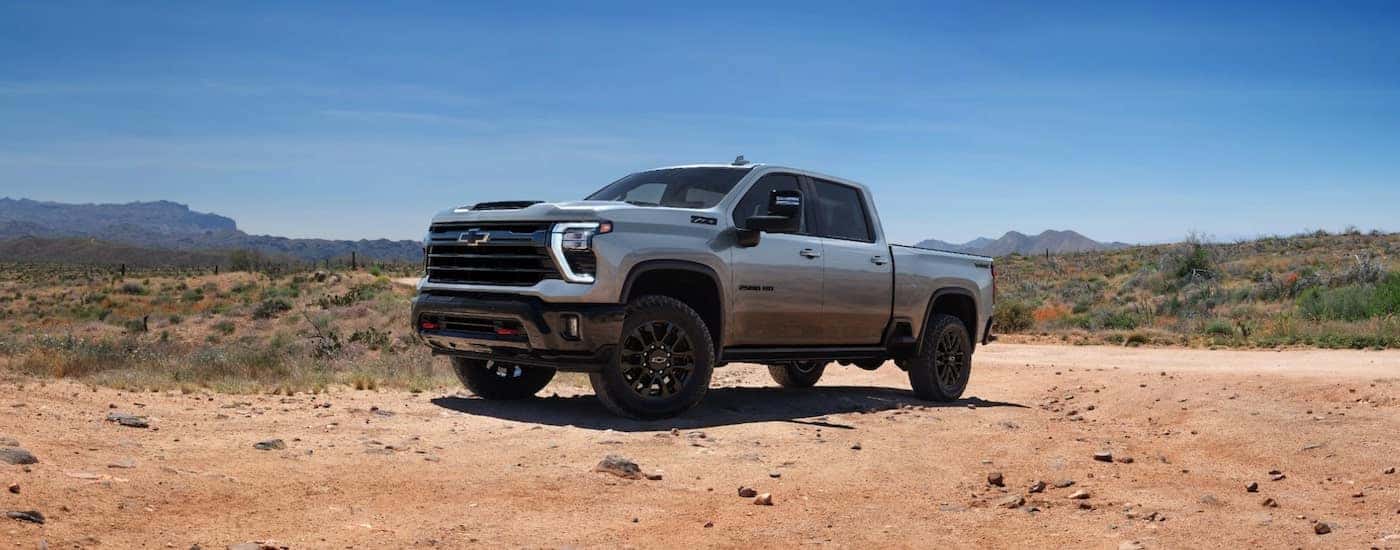 A grey 2025 Chevy Silverado 2500 HD parked off-road after visiting a dealer with a Chevy Silverado 2500 for sale near Mount Holly.