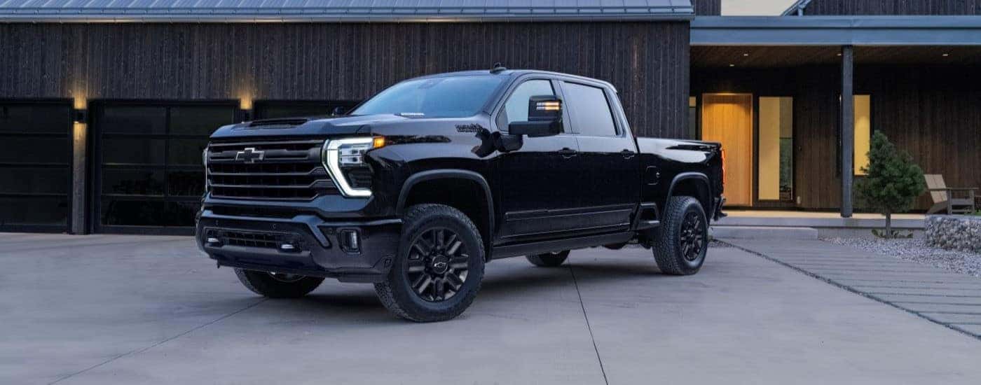 A black 2024 Chevy Silverado 2500 HD High Country Midnight parked outside of a building.