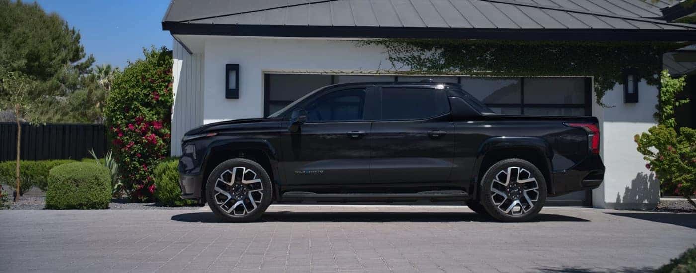 A black 2025 Chevy Silverado EV for sale near University City parked on a driveway.