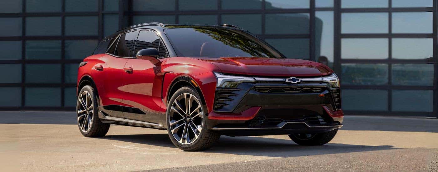 A red 2024 Chevy Blazer EV for sale near Belmont in front of a garage.