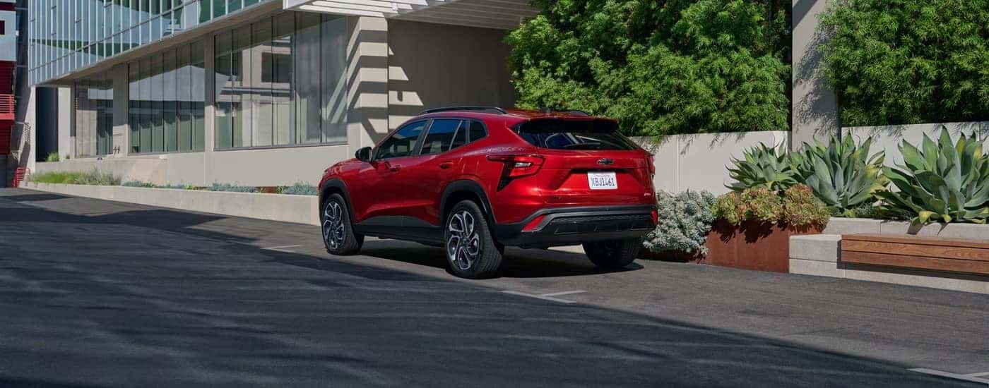 A red 2025 Chevy Trax RS parked on a city street.
