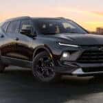 A black 2025 Chevy Blazer for sale is parked in a city.