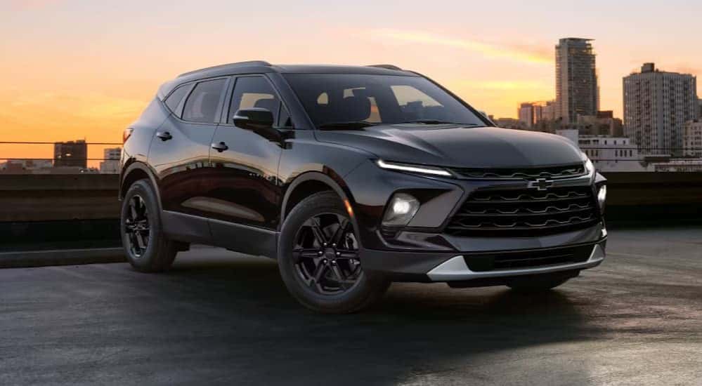 A black 2025 Chevy Blazer for sale is parked in a city.