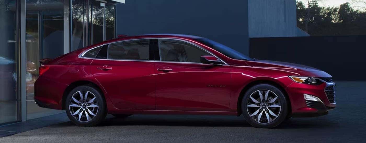 A red 2024 Chevy Malibu parked on a driveway.