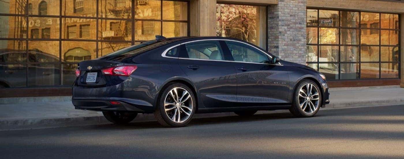 A black 2023 Chevy Malibu parked outside a building