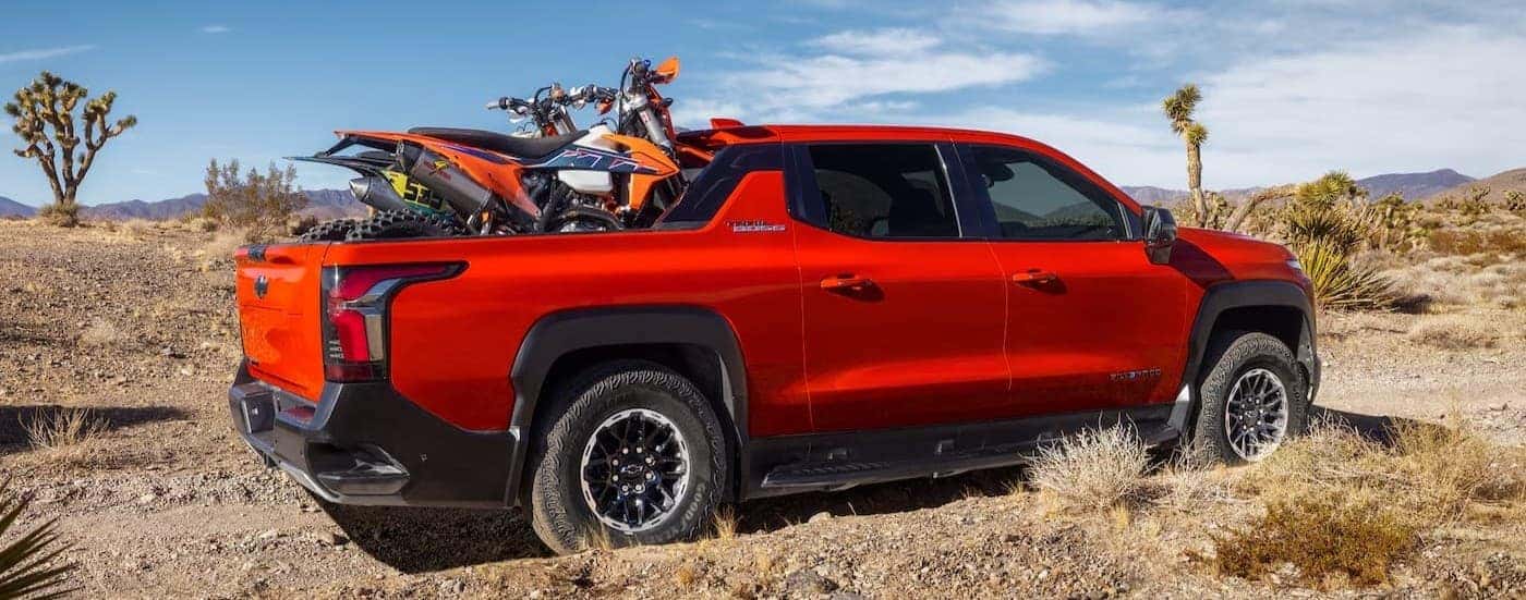 A red 2026 Chevy Silverado EV Trail Boss off-roading.