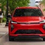 A red 2027 Chevy Bolt RS parked in a city.