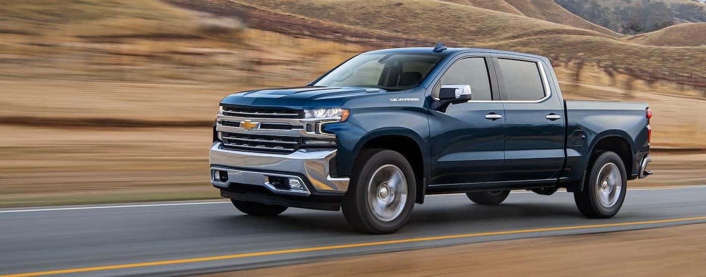 Blue 2021 Chevy Silverado 1500 driving to see used cars for sale