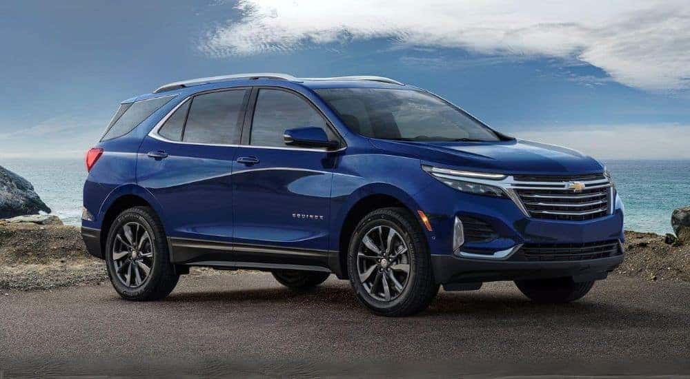 A blue 2023 Chevy Equinox parked near water.