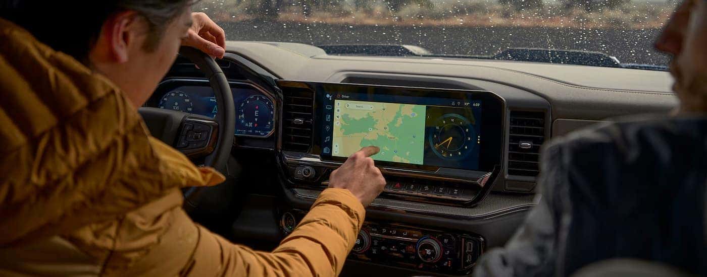 A man using the touchscreen infotainment display in a 2026 Chevy Silverado 1500