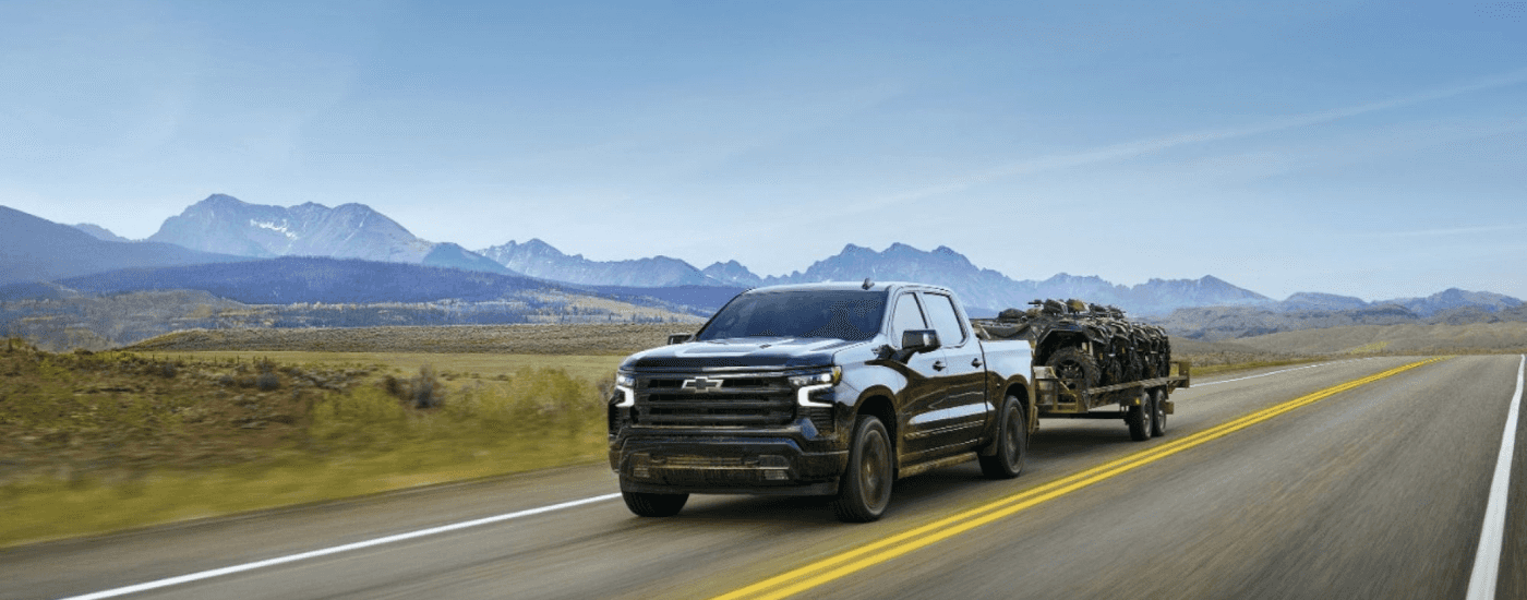 Black 2025 Chevy Silverado 2500 HD towing ATVs