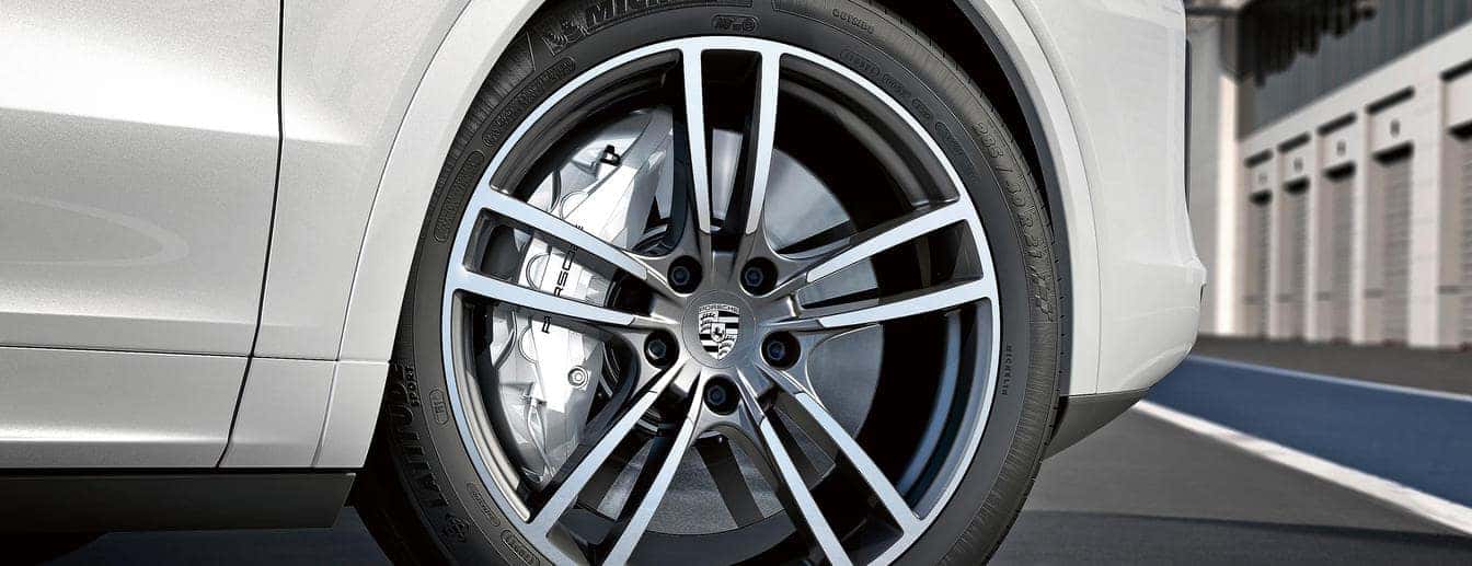 Zoomed in picture of tire and brake on a silver Porsche