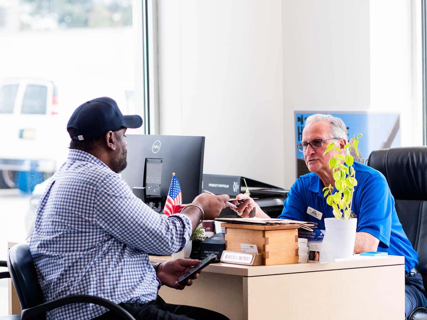 Two guys speaking at a desk