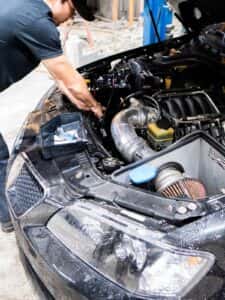 A mechanic inspecting a car underhood
