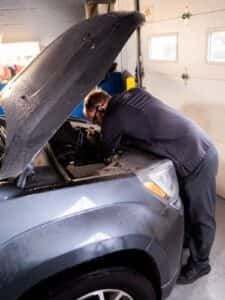 A mechanic checking the hood of the car