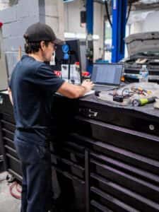 A car mechanic in front of a laptop