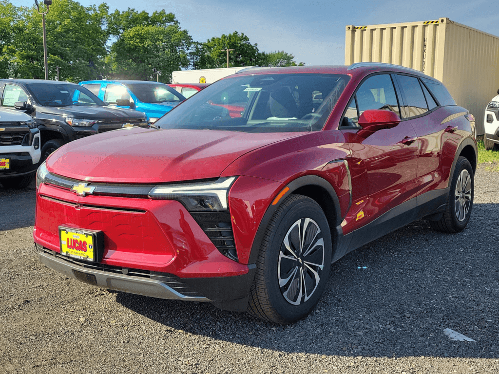 A red Chevy Blazer EV parked in a parking lot with multiple cars behind it.