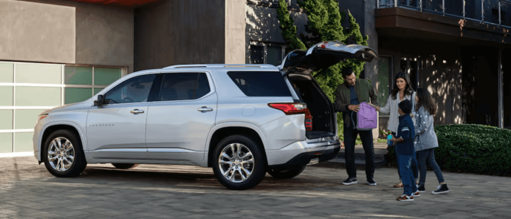 A couple and their two kids loading up their 2025 Chevy Traverse
