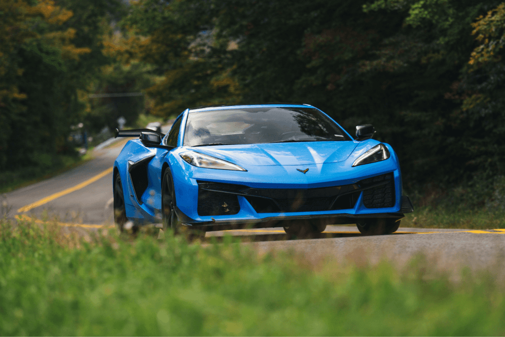 A blue Chevy Corvette Stingray driving along an empty road.