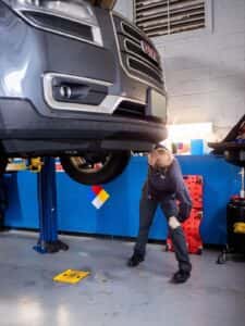 Automechanic inspecting underneath the car.