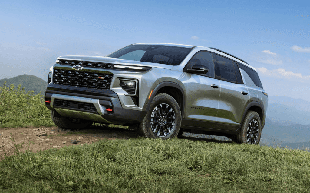 A new, light gray Chevrolet Traverse Z71 SUV is shown on a grassy, hilly terrain.