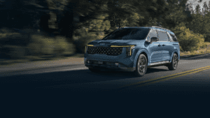 A navy blue Kia Telluride parked next to a rocky hill