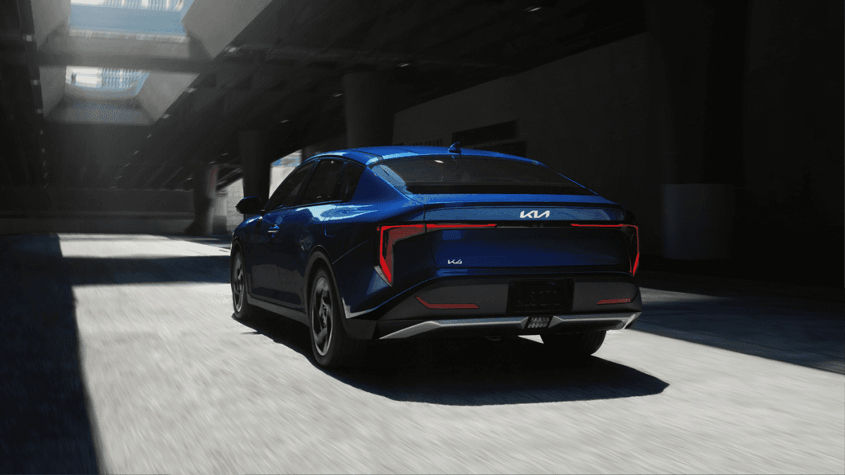 A blue 2025 Kia K4 driving through a parking garage