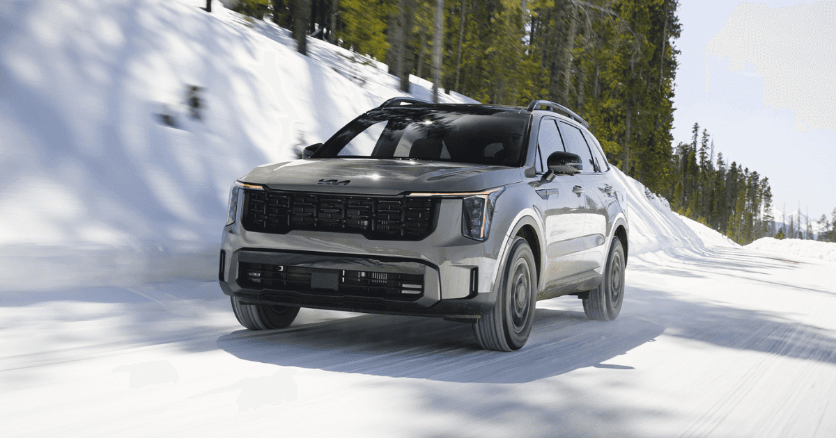A gray Kia Sorento driving over a snowy street