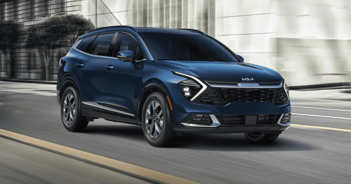 A blue Kia Sportage driving through a city