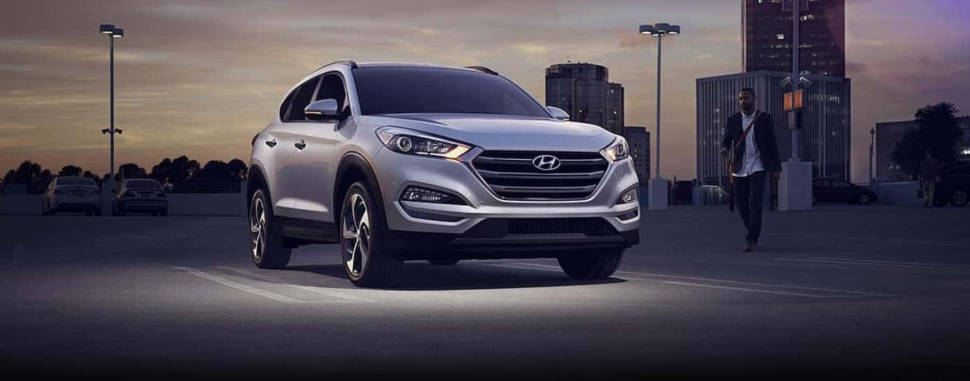 A silver 2016 Hyundai Tucson is shown at night.
