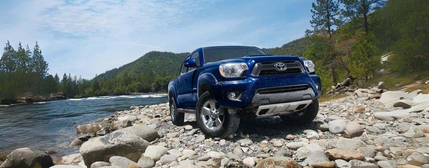 A blue 2015 Toyota Tacoma is shown on a lake shore after leaving a used car dealer near Seymour.