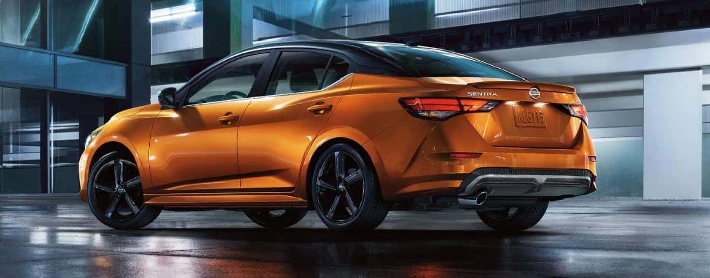 A metallic orange 2022 Nissan Sentra SR parked in a garage at night.