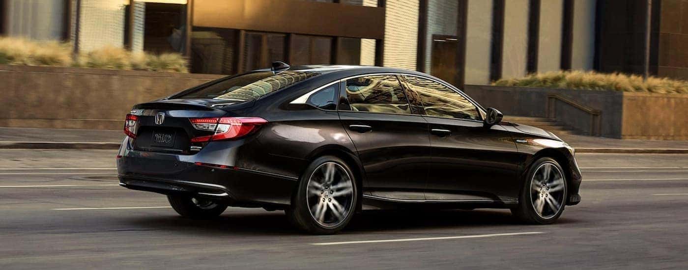 A black 2021 Honda Accord Hybrid driving through the city to view used cars for sale near Morristown.