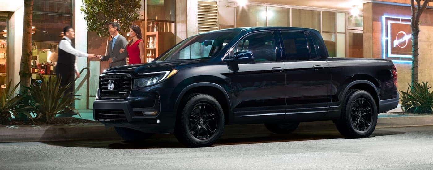 A Black 2020 Honda Ridgeline Black Edition is shown parked near a city curb.