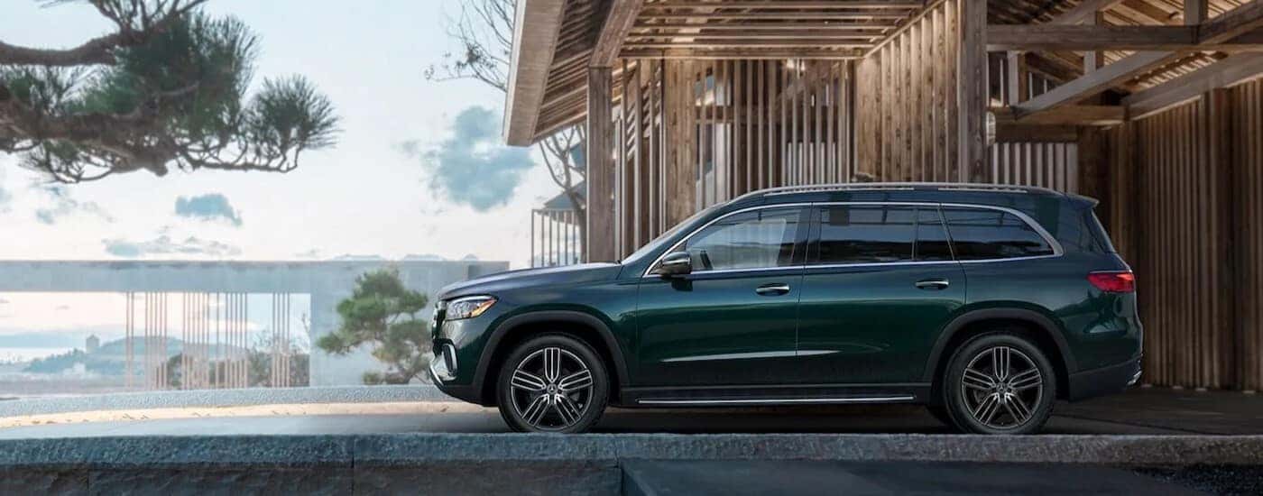 Side view of a green 2023 Mercedes-Benz GLS 450 Exclusive parked at a home under construction.