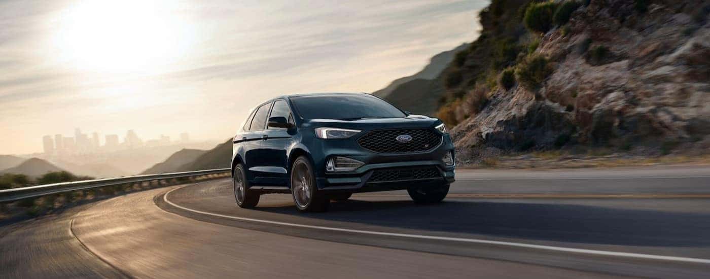 A green 2024 Ford Edge ST is shown driving on a highway.