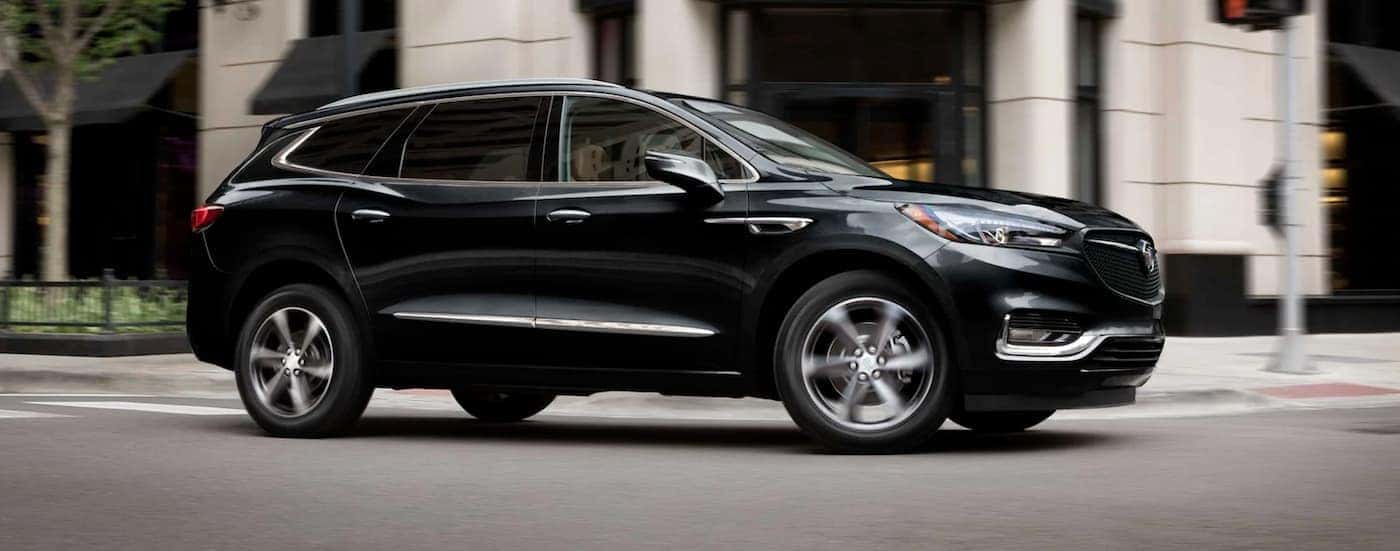 Black 2021 Buick Enclave driving through an intersection
