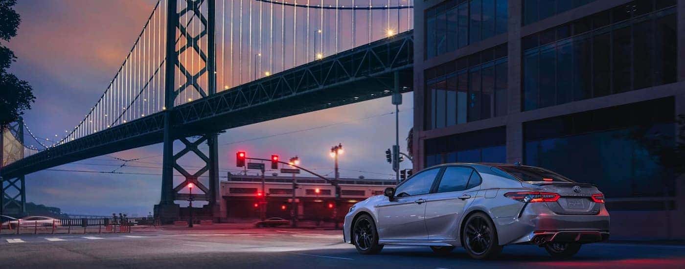 White 2020 Toyota Corolla stopped at an intersection near a large bridge