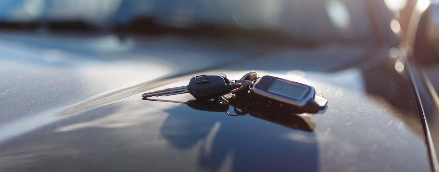 A set of car keys on the hood of a car.