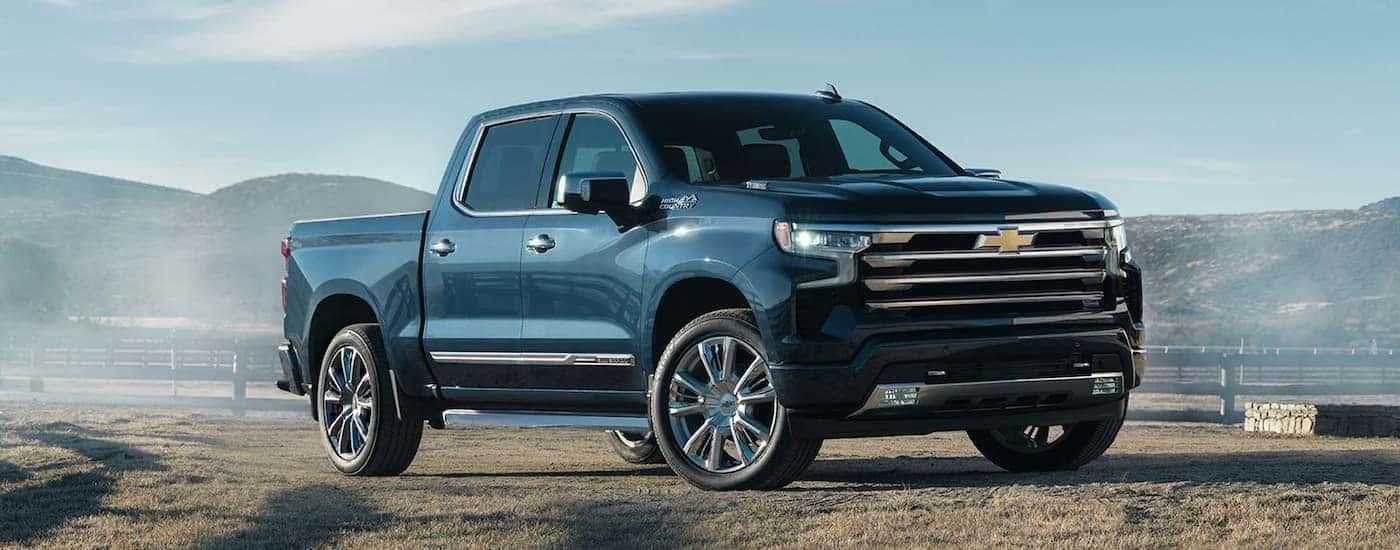 Blue 2022 Chevy Silverado 1500 High Country parked on a farm.