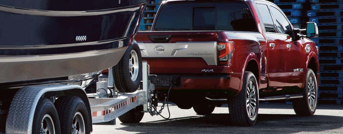 Red 2022 Nissan Titan Platinum is towing a boat