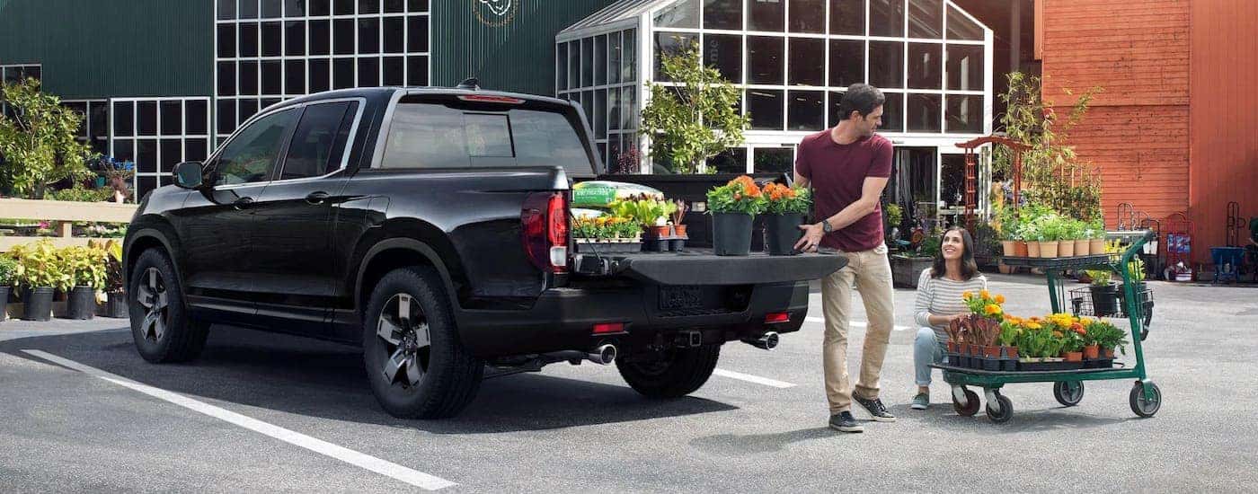 a black 2023 Honda Rigdeline is shown from the rear at an angle.