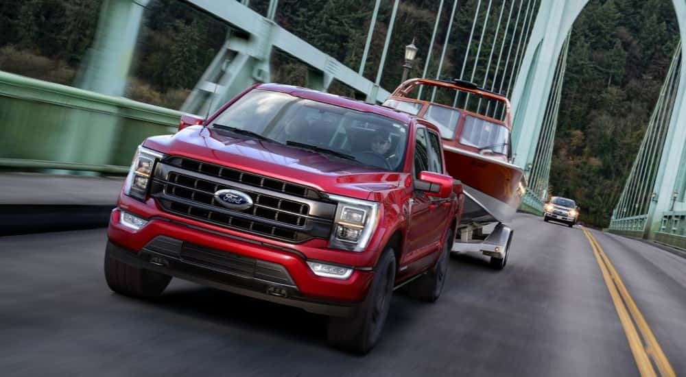 A red 2021 Ford F-150 towing a boat.