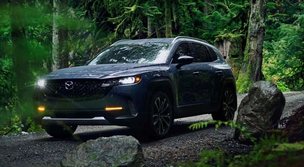 A blue 2023 Mazda CX-50 driving off-road.